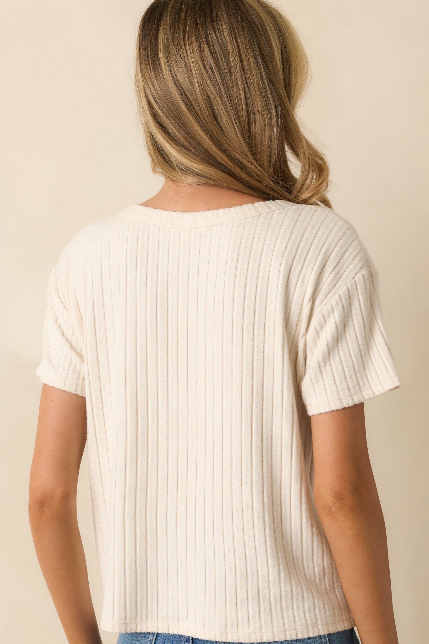 Rear view of the ivory ribbed tee with a boxy fit and short sleeves.