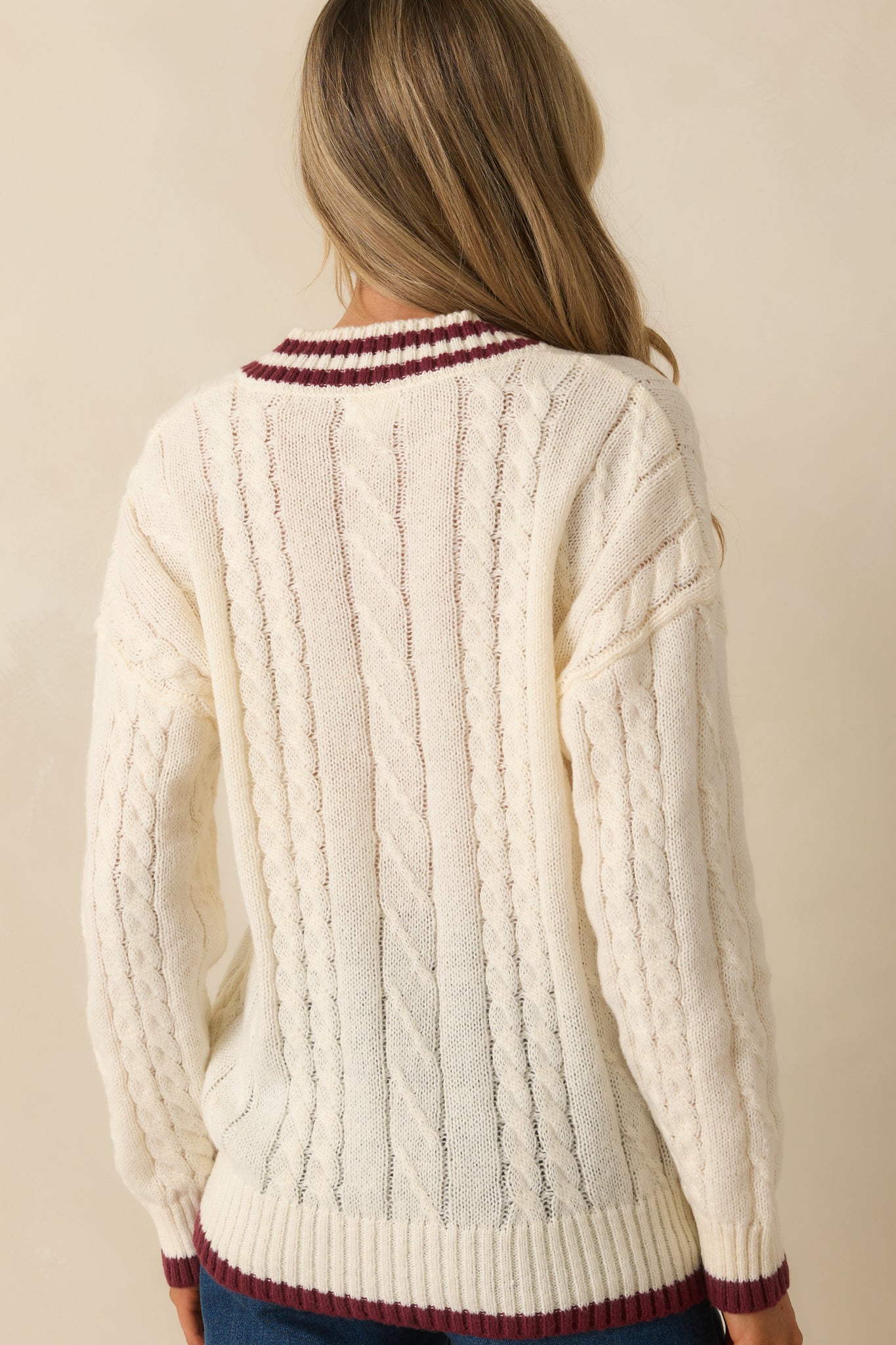Rear view of the ivory sweater showing the relaxed fit and long sleeves.