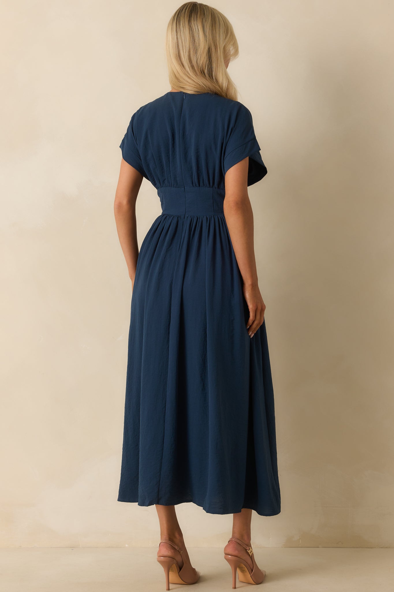 Rear view of the navy maxi dress with hidden zipper closure and flowing skirt.