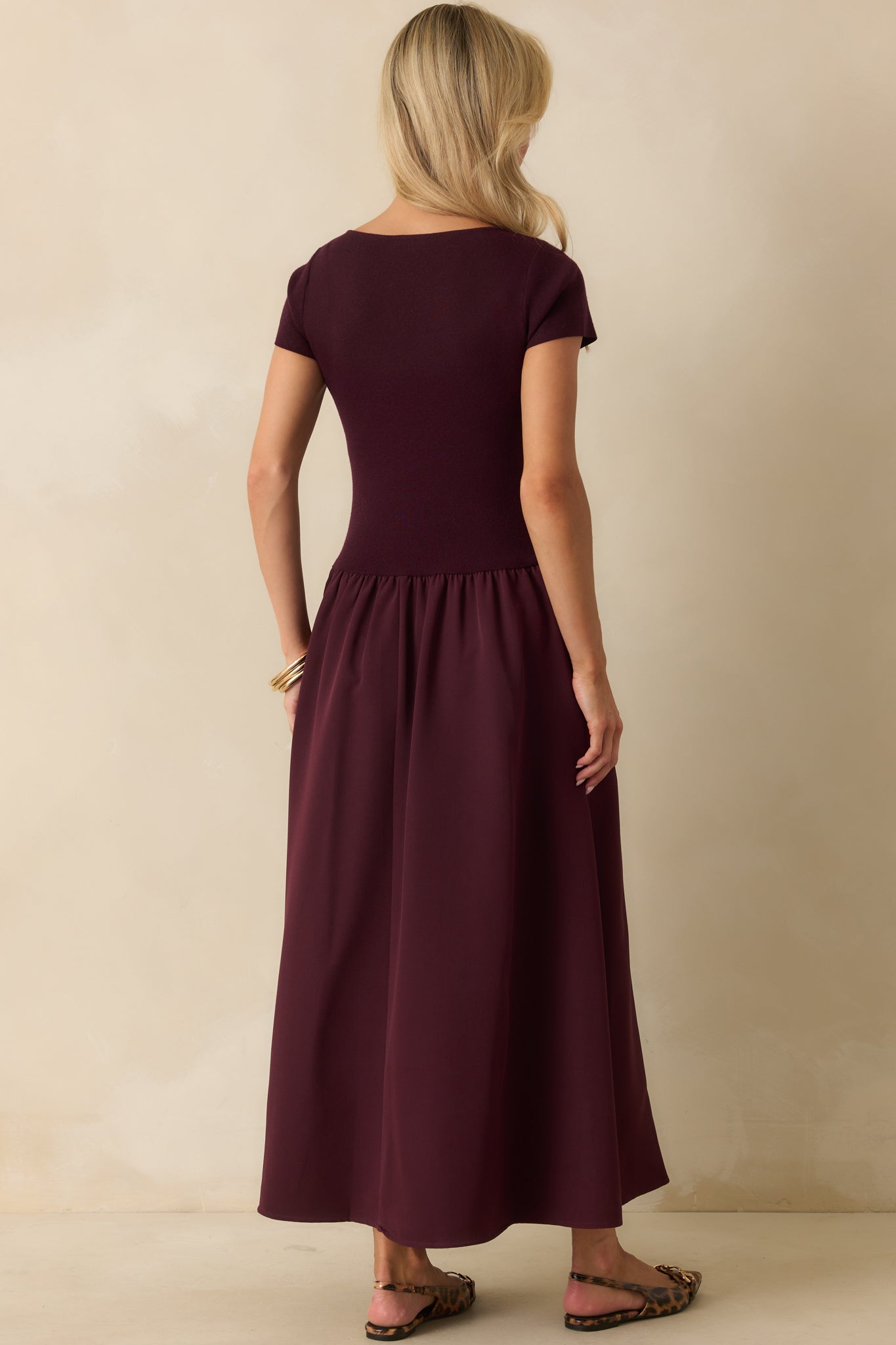 Rear view of the wine red maxi dress showing the smooth ribbed bodice and gathered skirt flow.