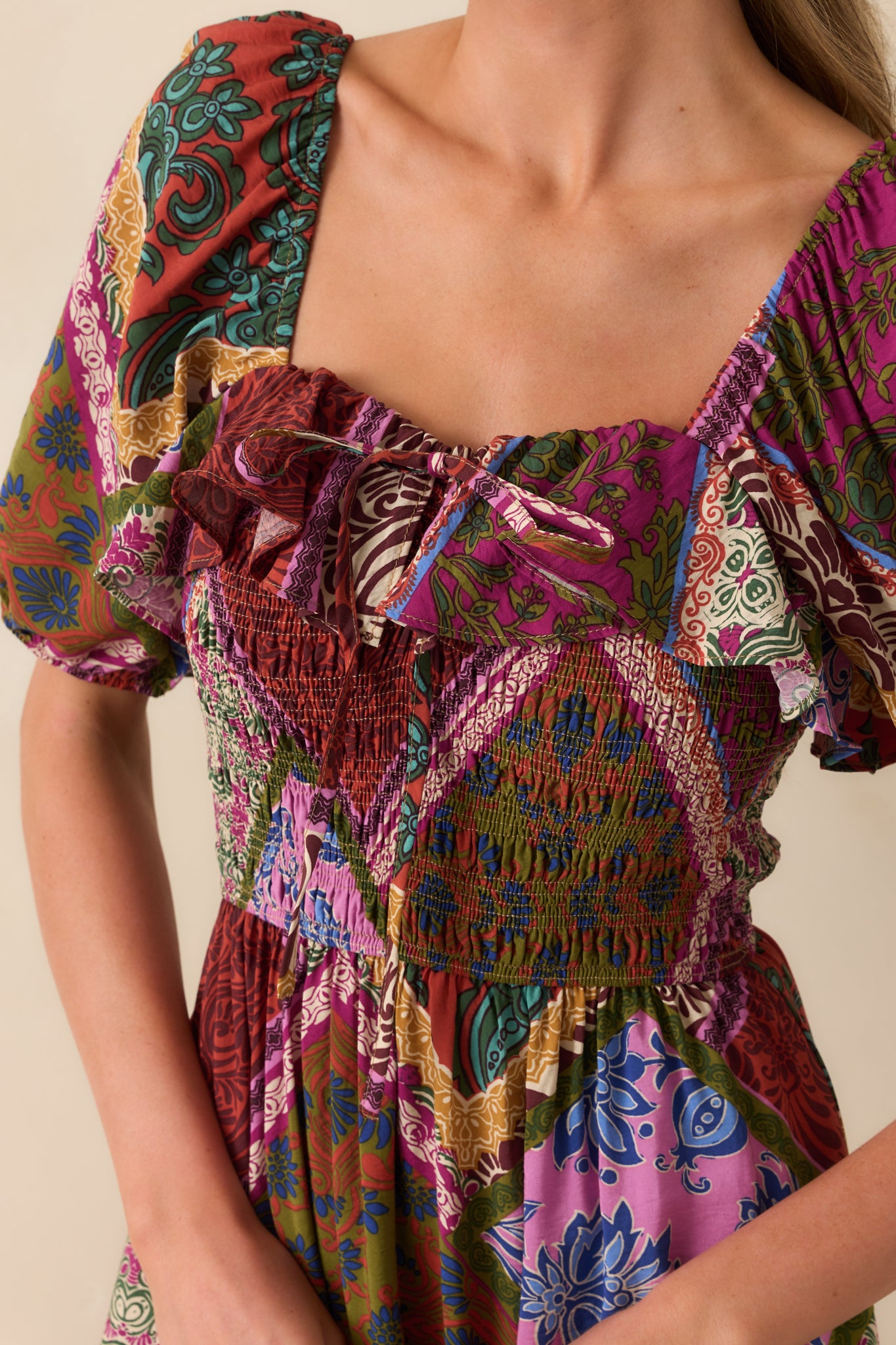 Close-up of smocked bodice with self-tie bow and ruffle detail at the sweetheart neckline.