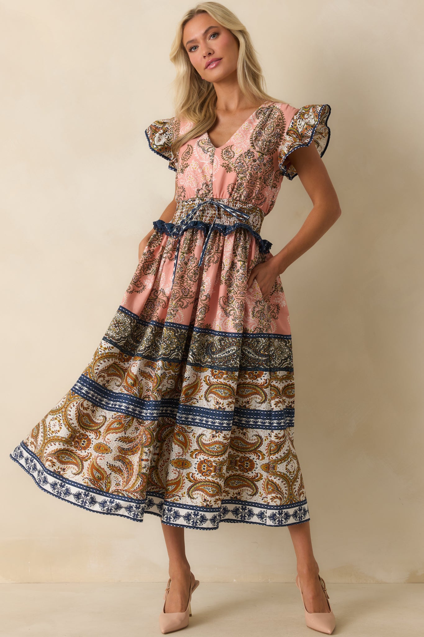 Rose pink midi dress with a multicolor paisley border print and v-neckline.