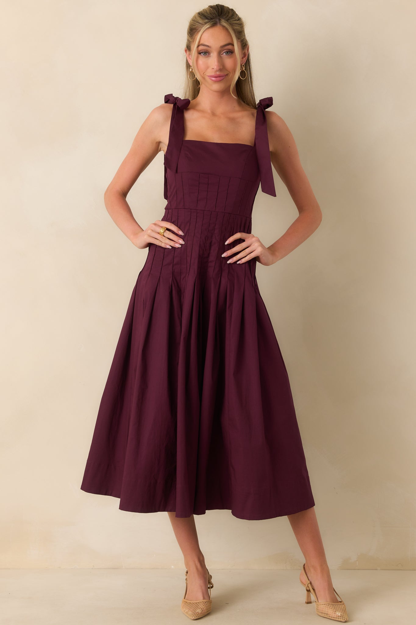 Sangria purple midi dress shown from the front, featuring smocked back panel and flowing pleated hem.