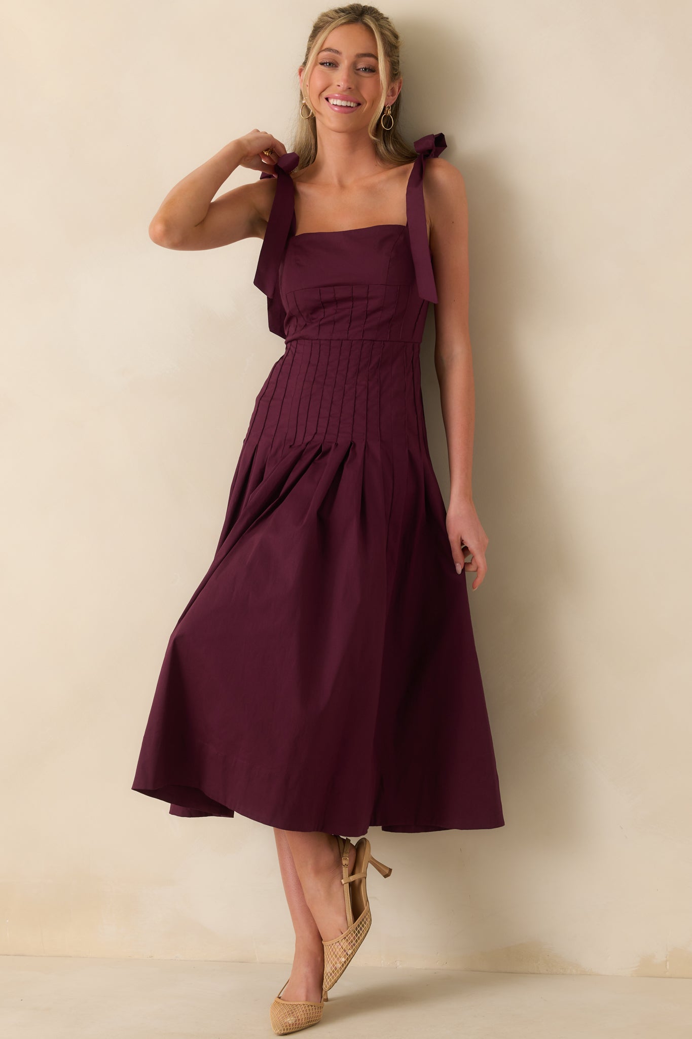 Front shot of sangria purple dress with pleated drop waist silhouette and smocked detailing at the back.