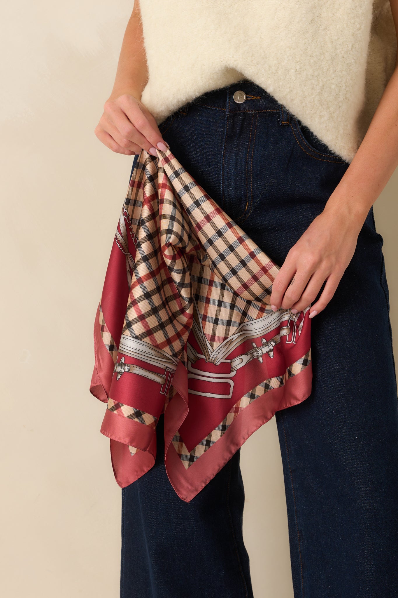 Square scarf with silky satin finish featuring beige, black, and red plaid print, burgundy border, and chain-and-buckle motifs.