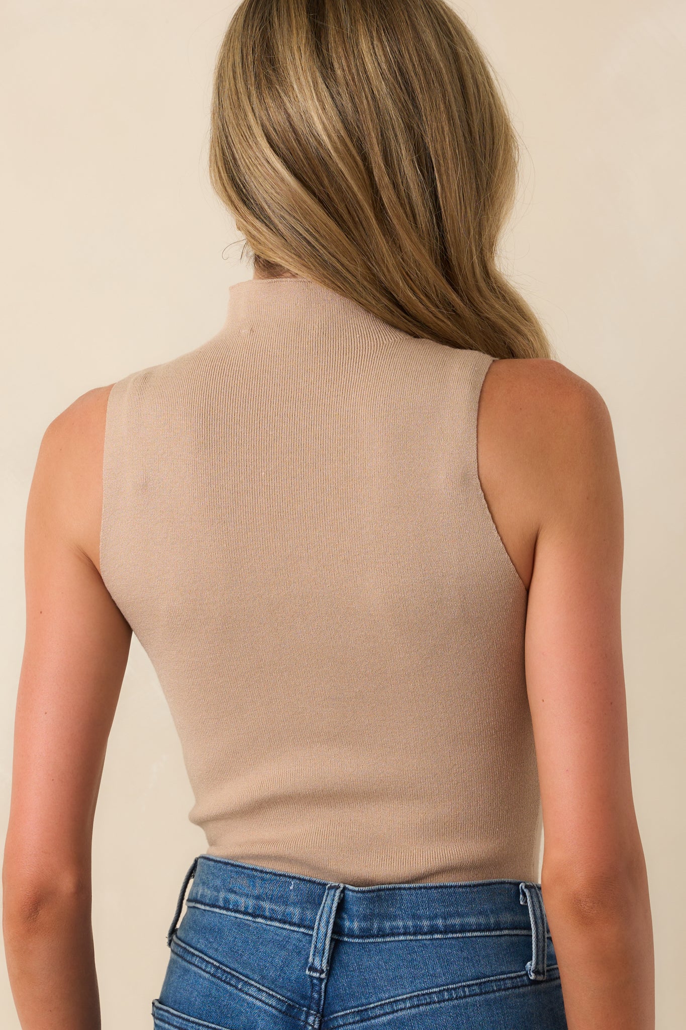 Rear view of the taupe bodysuit displaying the clean back silhouette and smooth continuation of the ribbed fabric.