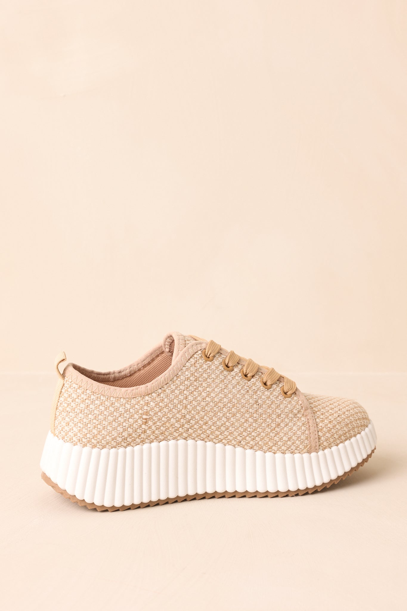 Rear view of tan sneakers with pull tab and cushioned sole visible.