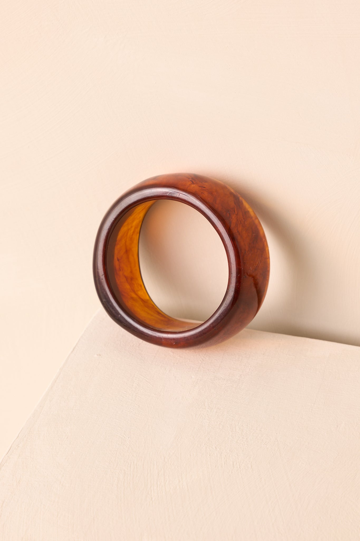 A close-up cropped shot highlighting the marbled tortoise shell pattern and slip-on shape.