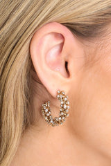 Model shown wearing earrings that feature rhinestones all over, an open hoop design, and secure post-back fastenings.
