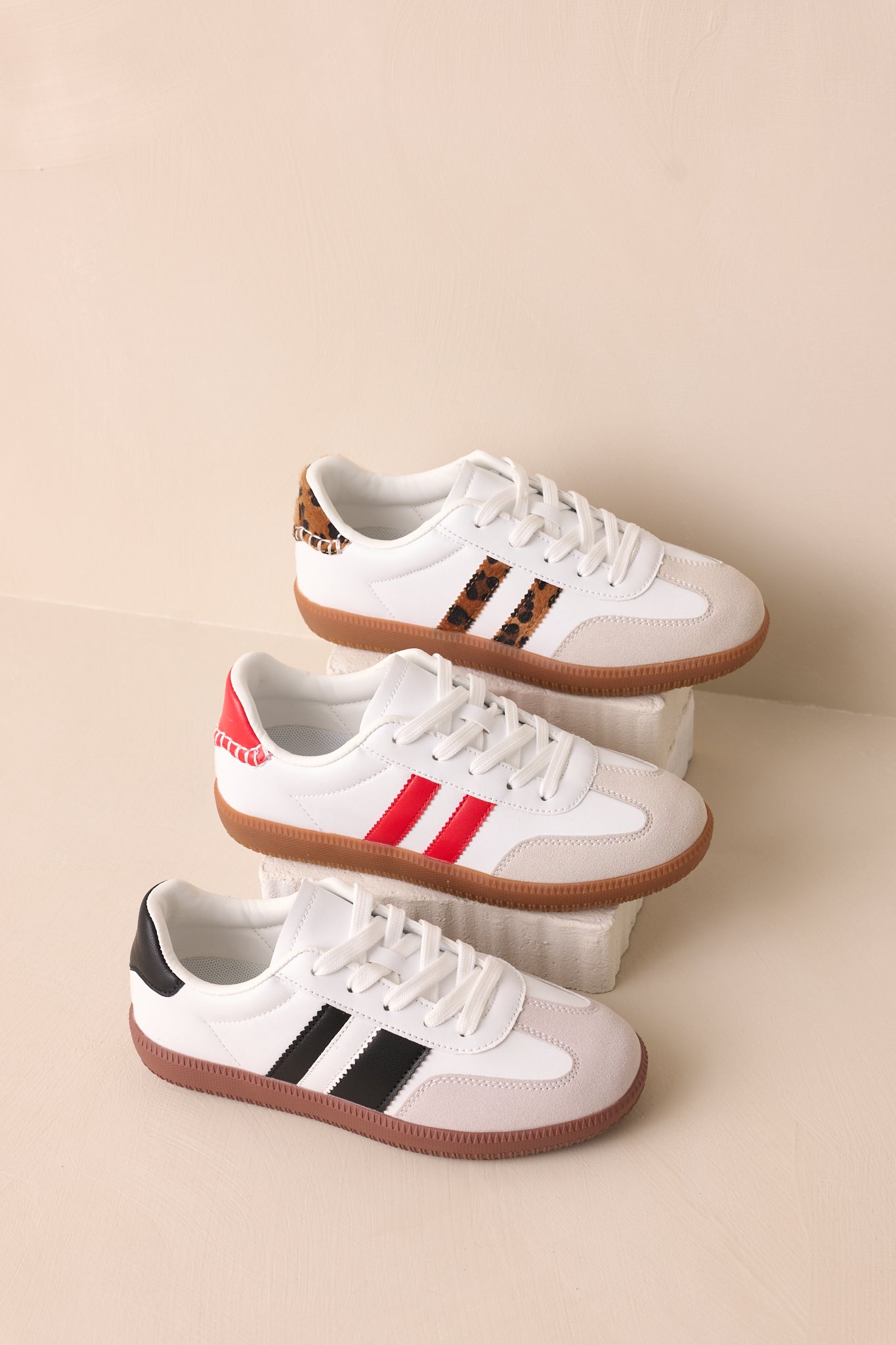 An overhead shot of the white sneakers, showcasing their various colors while keeping the classic design of a rounded toe, thick rubber sole, and crisp white laces.