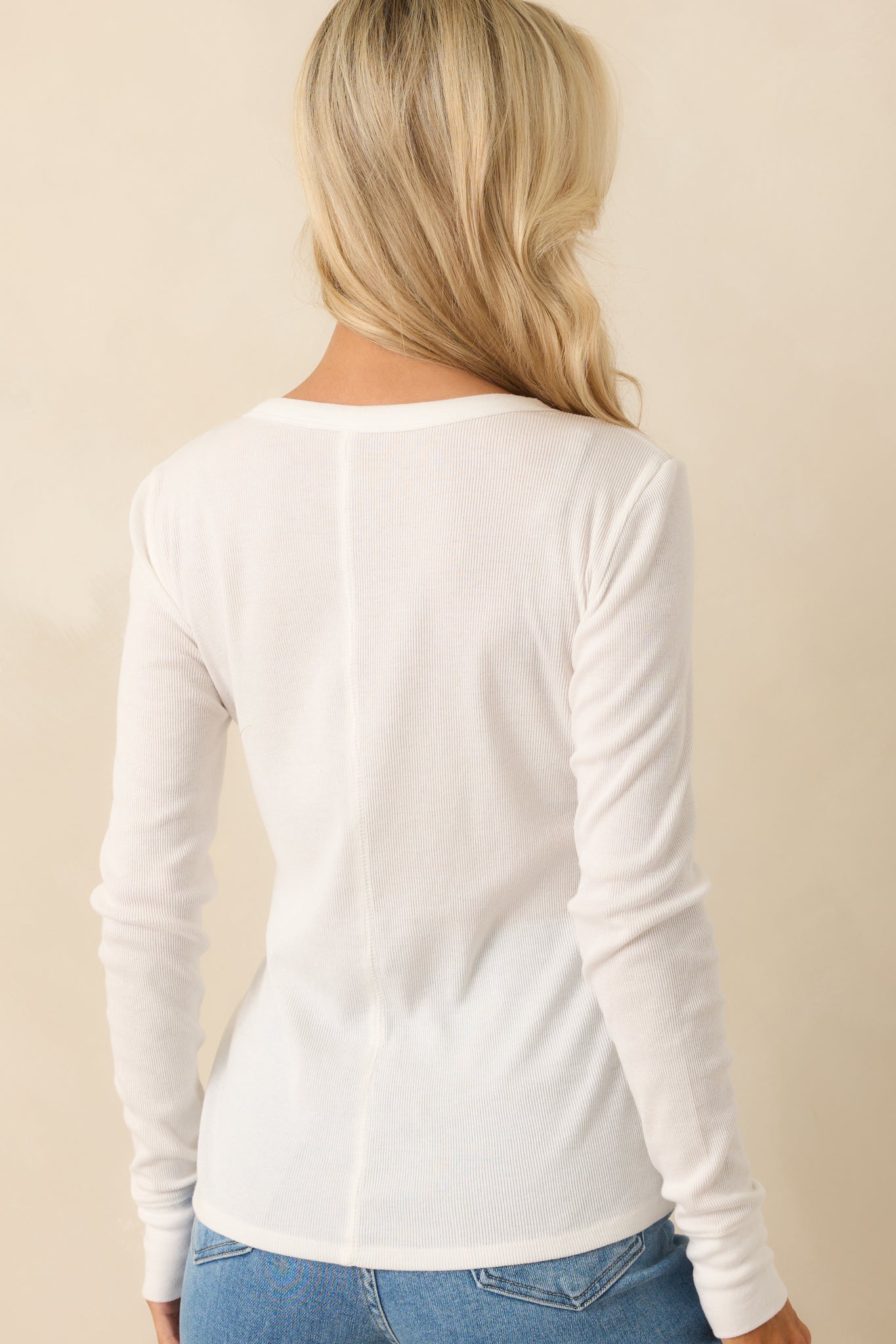 Rear view of the ivory top displaying the center seam detail and smooth drape of the ribbed fabric across the back.