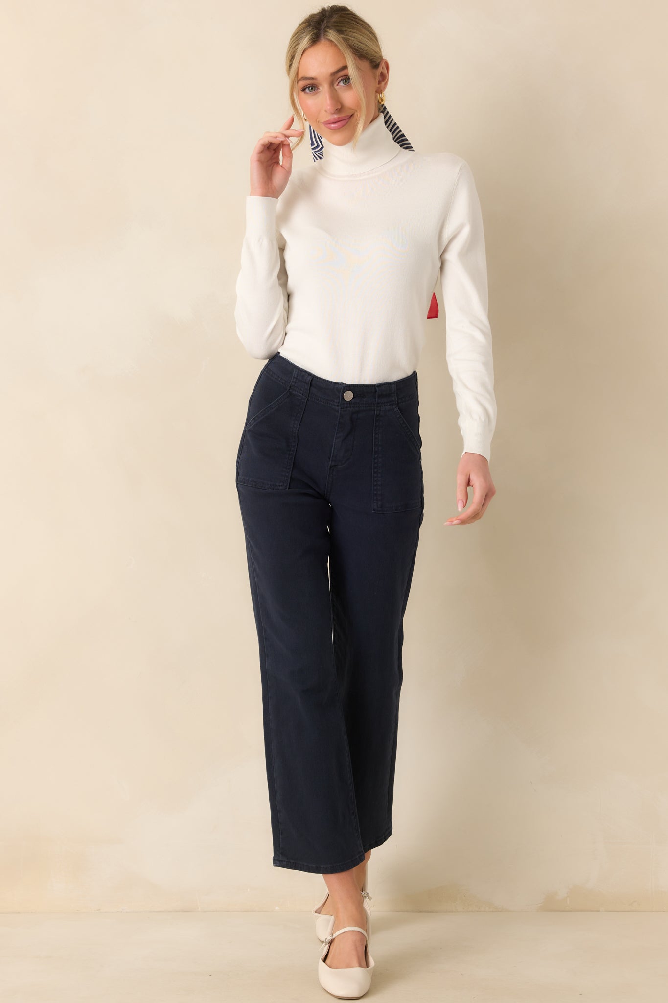 Full body shot capturing the soft texture and shape of the ivory sweater from top to hem.