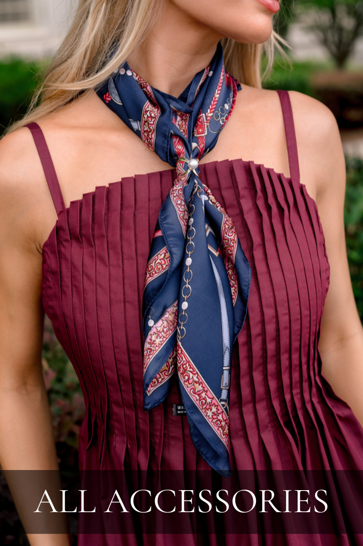 Woman styling a navy printed scarf with a burgundy pleated dress. Scarf is featured in All Accessories collection.