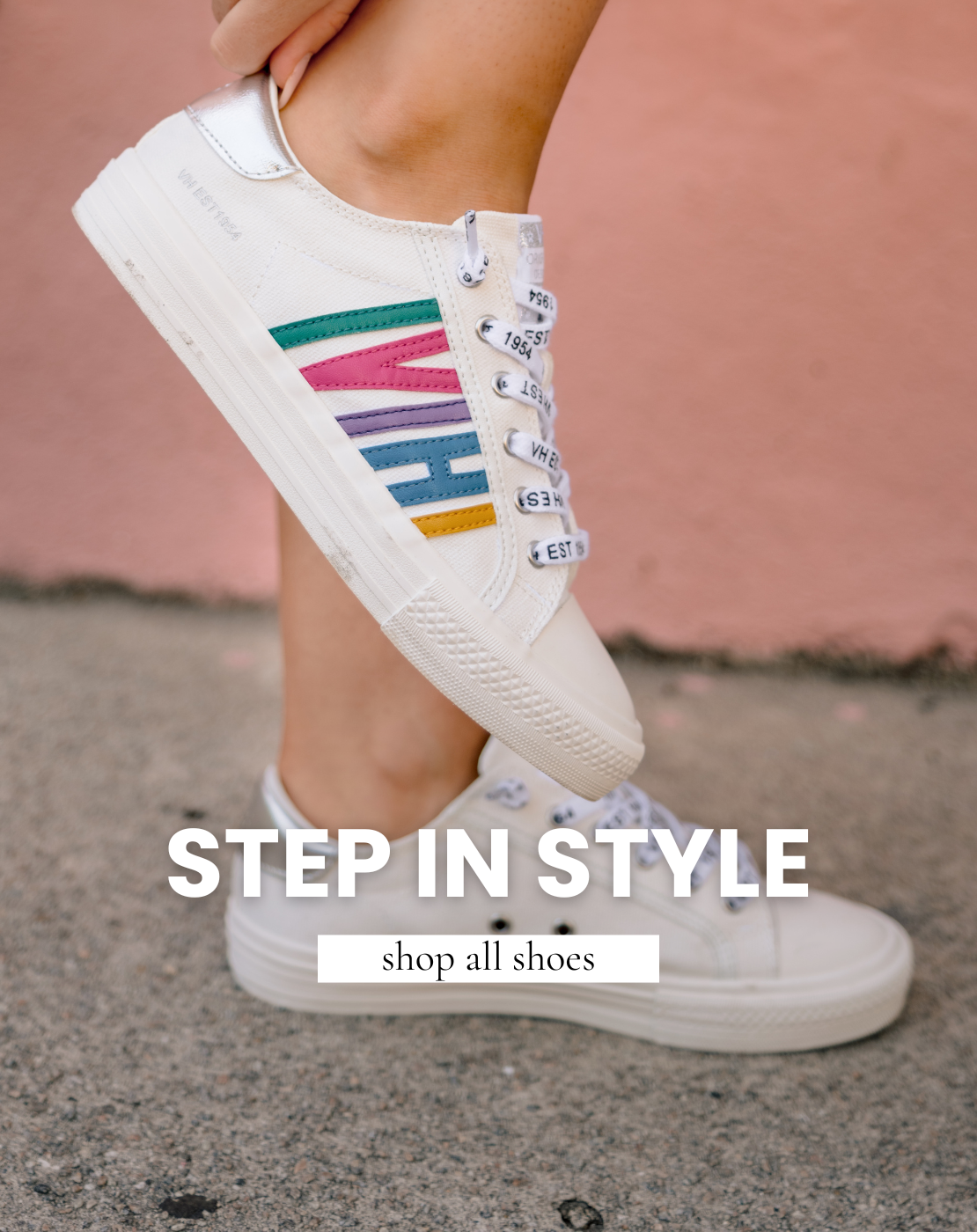 Close-up of women's white canvas sneakers featuring colorful retro-inspired side stripes in pink, turquoise, lavender, blue, and yellow. Styled on model outdoors with a casual summer outfit, showcasing metallic silver heel accents and classic lace-up design.
