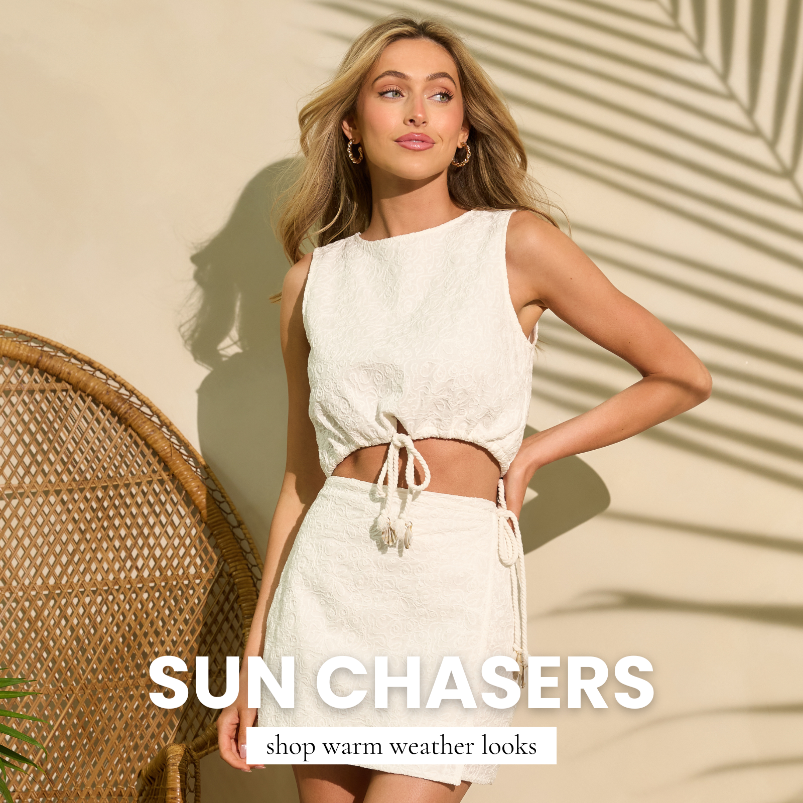 Model wearing a cream sleeveless crop top and matching skirt in a sunlit setting, women’s fashion boutique shop linking to shop warm weather and vacay looks.