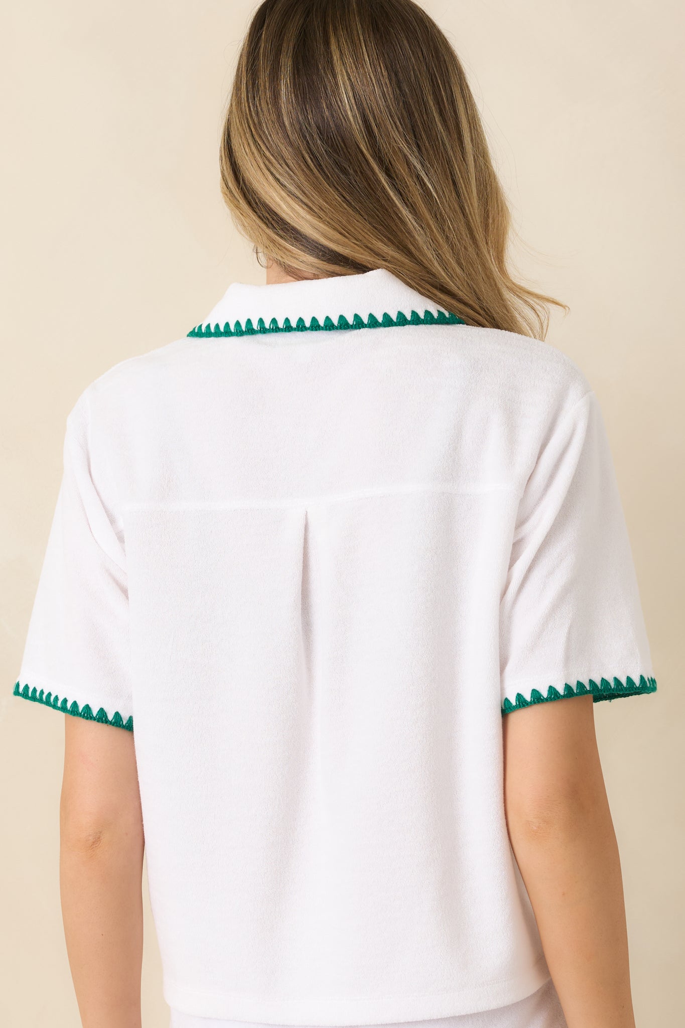 Back view of the white cotton-blend button-down top featuring the relaxed silhouette, soft fabric texture, and short sleeve design.