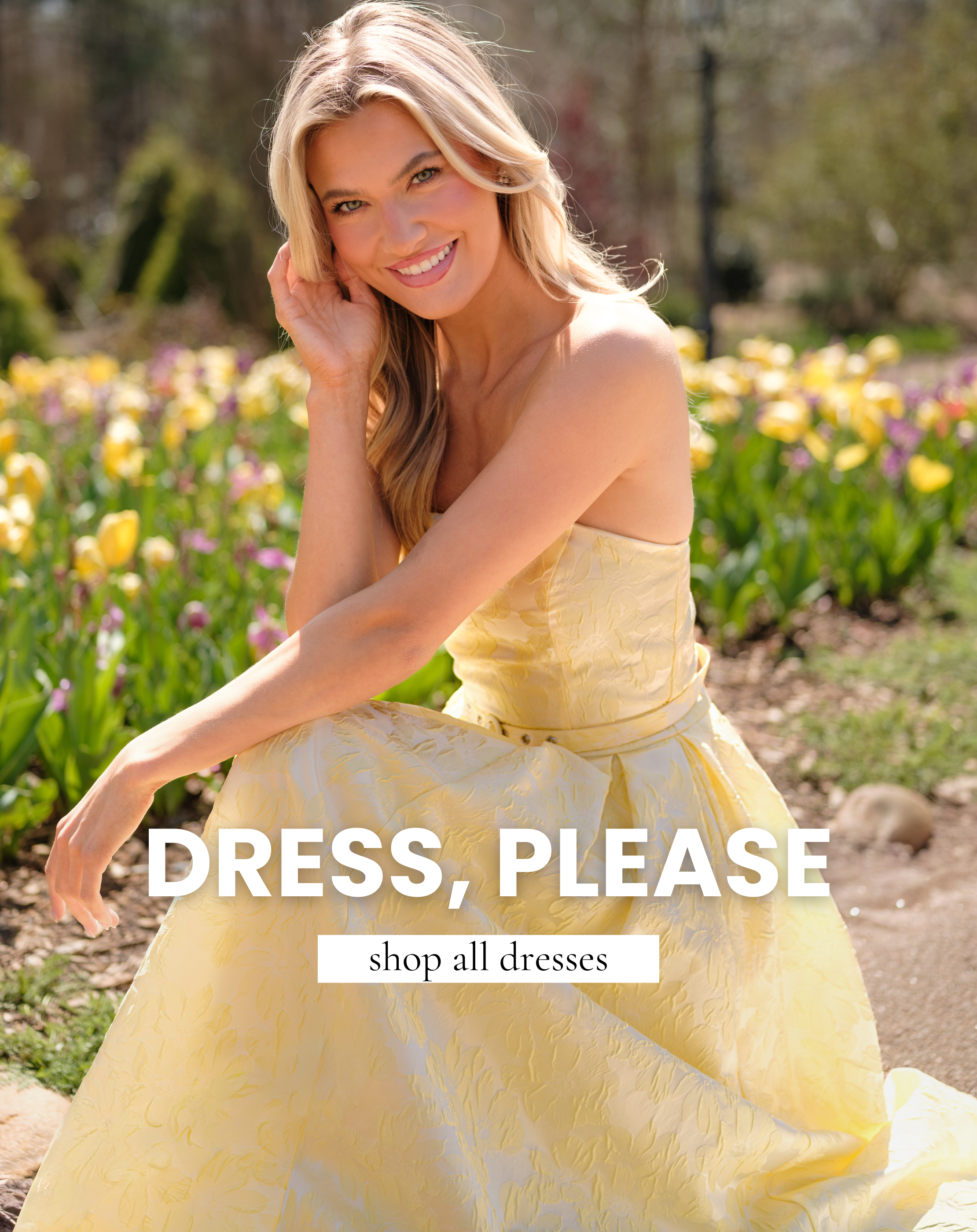 Woman wearing a yellow textured floral midi dress sitting in a garden of blooming flowers, capturing a soft and romantic spring look. This image leads to shop all dresses and highlights feminine silhouettes perfect for daytime events.