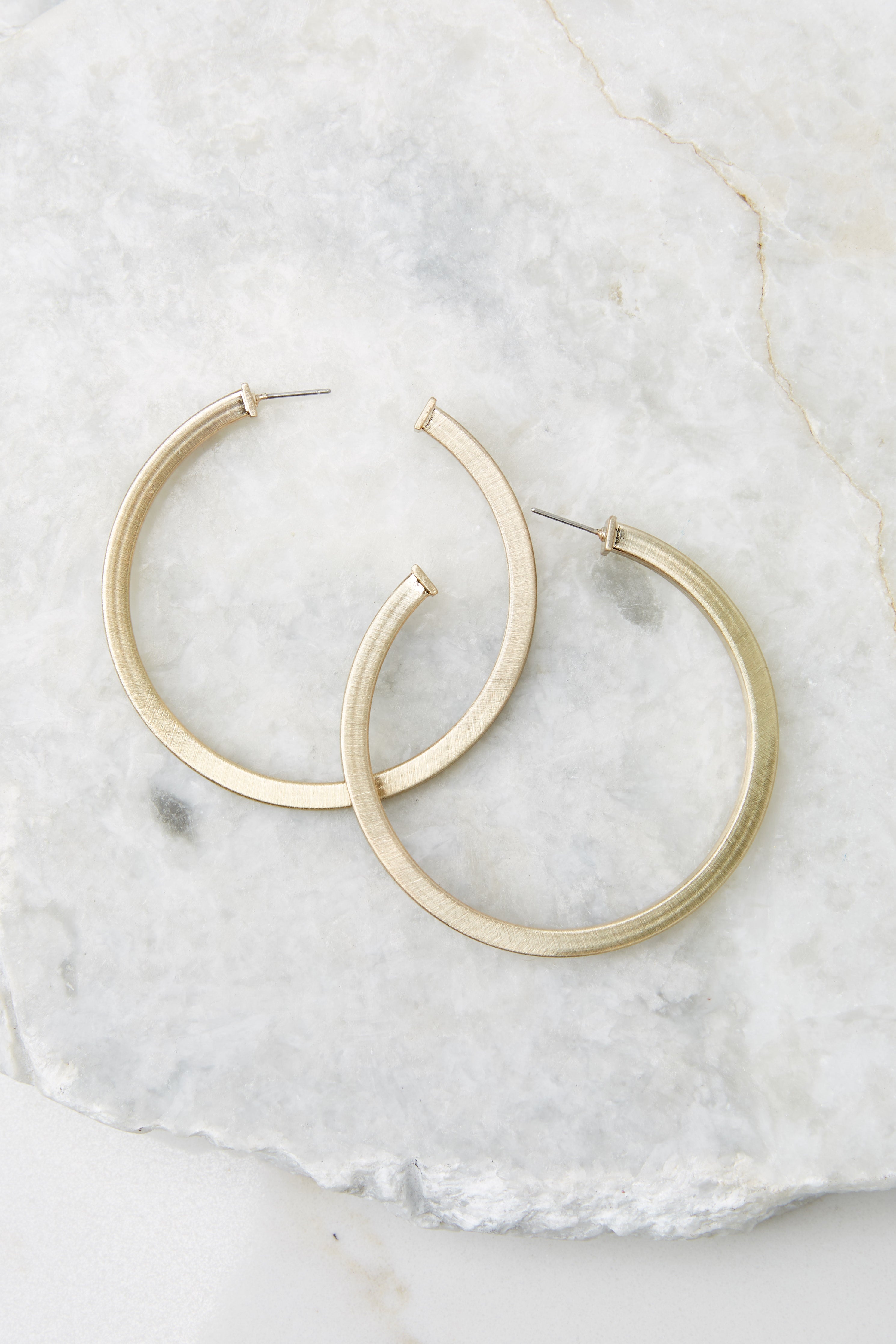 These gold earrings feature a hoop design, box body, and a post secure backing. 