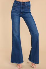 These dark wash jeans feature a high waist, belt loops, front and back pockets, and a hemmed and flared bottom.