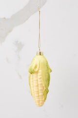 This yellow ornament features a design of corn with green glitter detailing on the ends.