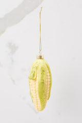 Front view of this ornament that features a design of corn with green glitter detailing on the ends.