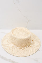 Full view of this hat that features a shell lining and a strap with seashell detail.
