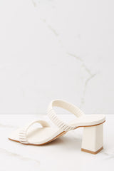 Inner-side view of these heels that feature a square toe, a slip on design, a thick heel and straps across the top of the foot.