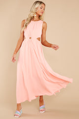 This peach colored dress features a back zipper, two side cutouts and another midriff cutout.
