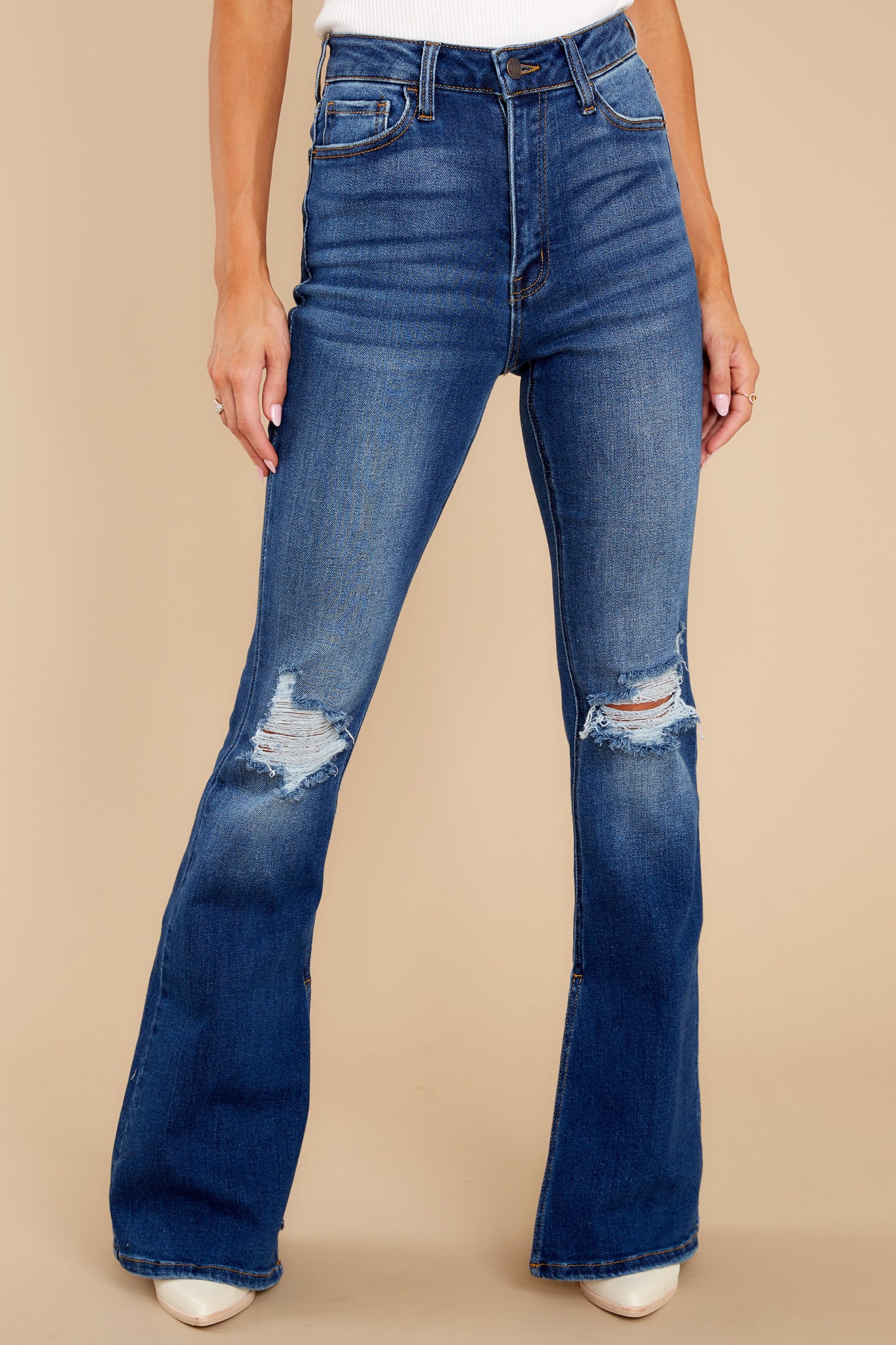 Front view of these jeans that feature light distressing throughout, wide legs, 3 functional front pockets, and a standard zipper and button closure.