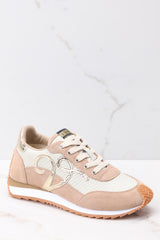 These beige shoes feature a gold design on the side and comes with an extra pair of laces. 
