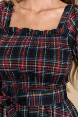 close up of black plaid midi dress with smocked bust and puffed sleeves. 