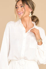 Front view of this top that features a collared neckline, functional buttons down the bodice, one pocket on the bust, and wide sleeves with buttoned cuffs.