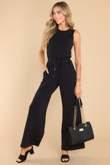 This all black jumpsuit features a round neckline, a keyhole cutout at the back of the neck with a button closure, a stretchy waistband with a self-tie drawstring, functional pockets at the hip, and a wide, flowy leg. 
