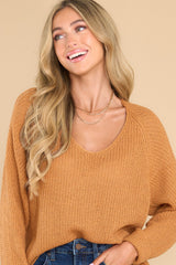 Front view of  this sweater that features a subtle v-neckline, long sleeves with tapered cuffs, a bottom hem that is approximately 2
