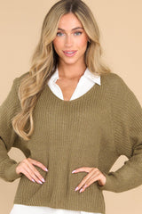 Front view of  this sweater that features a subtle v-neckline, long sleeves with tapered cuffs, a bottom hem that is approximately 2