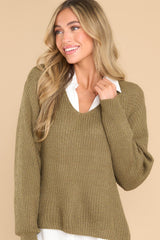 Front view of  this sweater that features a subtle v-neckline and long sleeves with tapered cuffs.