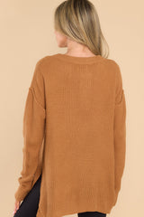 Back view of this sweater that features a round neckline with four button closures, long sleeves with tapered cuffs, slits up the sides of the bottom hem, and a waffle knit texture throughout.