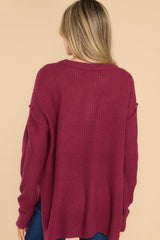 Back view of this sweater that features a round neckline with four button closures, long sleeves with tapered cuffs, slits up the sides of the bottom hem, and a waffle knit texture throughout.
