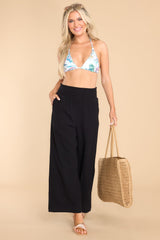 Full body view of these pants that features a smock stretch waistband, pockets at the hip, and a wide flowy leg.