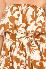 Close up view of this jumpsuit that features an elastic strapless neckline, a self-tie belt at the waist, an elastic waistband, and a wide-leg design.