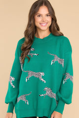 This green sweater features a high round neckline, long balloon sleeves with stretchy cuffs, a bottom hem that tapers in and has two small slits on the sides, and a soft material with lots of stretch throughout.