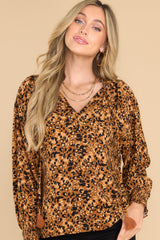 Front view of this top that features a v-neckline with a self-tie closure, long sleeves with smocked cuffs, and gold metallic detailing throughout.