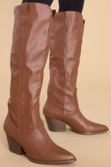 Full view of these boots that feature a pointed toe, a slip-on style, and a stacked heel.