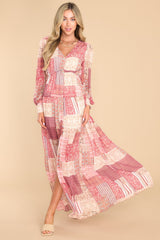 This pink maxi dress features a v-neckline, buttons down the bodice, balloon sleeves with buttoned cuffs, an elastic waistband, and a flowy skirt.