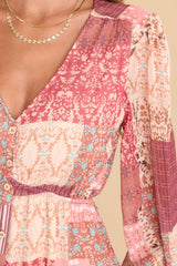 Close up view of this maxi dress that features a v-neckline, buttons down the bodice, balloon sleeves with buttoned cuffs, an elastic waistband, and a flowy skirt.