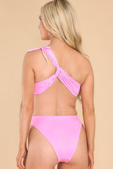 Back view of this swimsuit that features a one shoulder neckline, adjustable tie on the shoulder, no padding through the bust, cut-outs on the waist, moderate coverage, and a high leg.