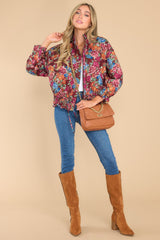 This multi-colored floral print quilted jacket features a high neck collar, elastic cuffs, functional waist pockets, zipper closure with snap buttons, an adjustable drawstring at waist, and elastic at the back.