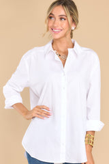 Front view of this top that features a collared neckline, functional buttons down the front, long sleeves with buttoned cuffs, and a scoop bottom hem.