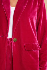 Close up view of this jacket that features a collared neckline, one functional bronze button at the waist, and functional pockets at the waist.