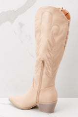 Outer-side view of these boots that feature a pointed toe, a half-length side zipper, a faux leather finish with stitched detailing throughout, and a non-skid rubber sole.